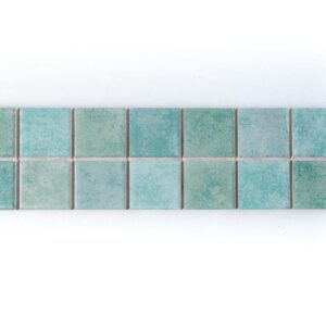 Vista frontale del Listello Vietrese Giada 7×22 cm di Savoia Ceramiche, con due file di quadrati verde giada e acquamarina.